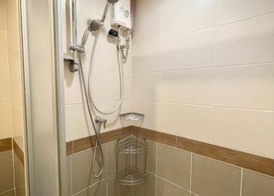 Modern bathroom with wall-mounted showerhead and tiled walls