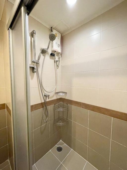 Modern bathroom with wall-mounted showerhead and tiled walls