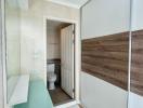 Bright bathroom with mirrored wardrobe doors and tiled flooring