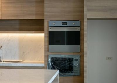 Modern kitchen interior with built-in appliances and marble backsplash