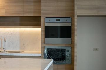 Modern kitchen interior with built-in appliances and marble backsplash