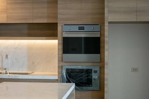 Modern kitchen interior with built-in appliances and marble backsplash