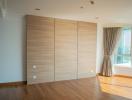 Spacious bedroom with large wooden wardrobe and ample natural light