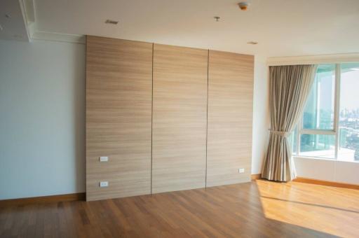 Spacious bedroom with large wooden wardrobe and ample natural light