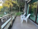 Spacious balcony with a view of greenery and seating area