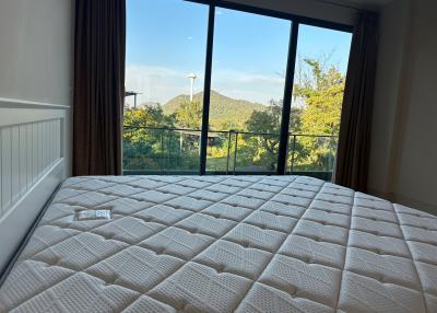 Spacious bedroom with large window offering a mountain view