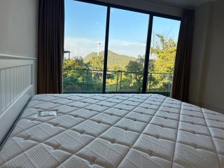 Spacious bedroom with large window offering a mountain view