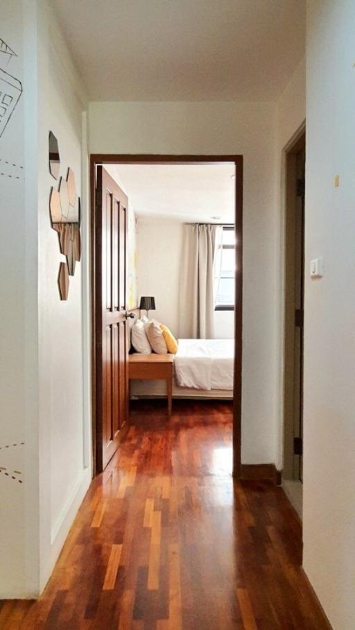 Cozy bedroom with wooden flooring and natural light