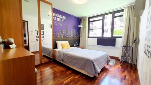 Cozy bedroom with a large window and wooden flooring