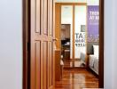 View from a bedroom doorway into a cozy, well-lit interior with wooden floors