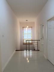 Bright corridor with tiled flooring and a hanging light fixture