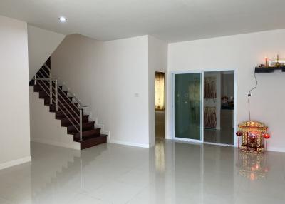 Spacious living room with staircase and shiny tiled flooring