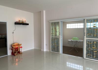 Spacious and bright living room with glossy tiled flooring and a decorative altar