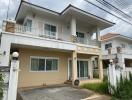 Two-story house with balcony and paved driveway