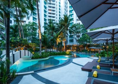 Luxurious apartment complex pool with garden and lounging areas