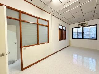 Empty interior space of a building with large windows and tiled flooring