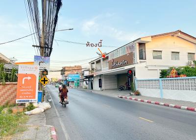 Street view of property showing residential buildings and shops