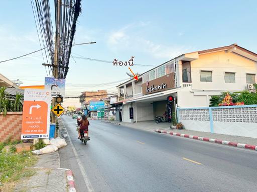 Street view of property showing residential buildings and shops