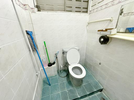 Compact bathroom with toilet and tiled walls