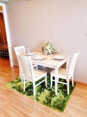 Cozy dining area with a white table and chairs set on a vibrant green rug