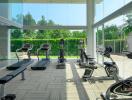 Home gym with exercise equipment and large windows overlooking greenery