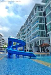 Bright and inviting outdoor swimming pool with a blue slide at a modern residential building