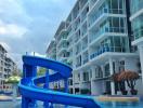 Bright and inviting outdoor swimming pool with a blue slide at a modern residential building