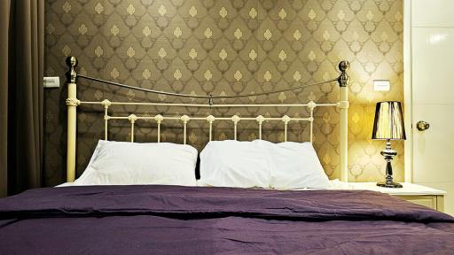 Elegant bedroom with decorative wallpaper and vintage bedside lamp