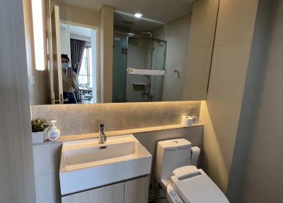 Modern bathroom with well-lit mirror and contemporary fixtures