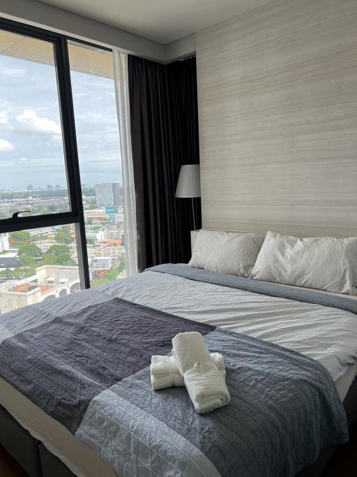 Cozy bedroom with a large window overlooking the city