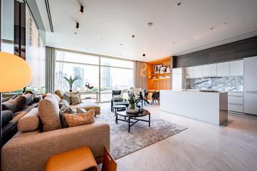 Spacious and modern open plan living room with kitchen, large windows, and city view