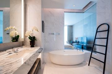 Modern bathroom interior with marble finish and stand-alone bathtub