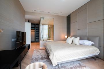 Modern bedroom with large bed, en-suite bathroom, and balcony access