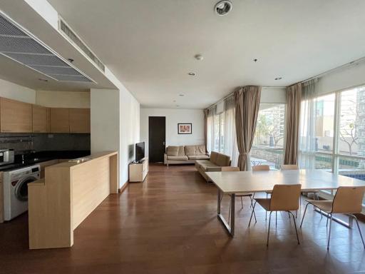 Spacious open plan living room with dining area, kitchen, and balcony access