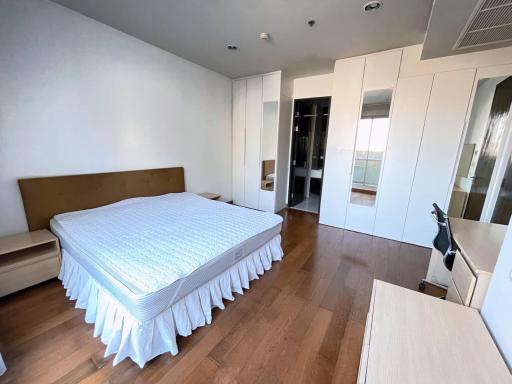 Spacious bedroom with wooden flooring and built-in wardrobe