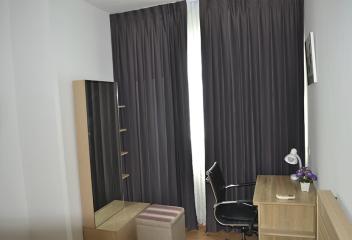 Modern bedroom with office corner and privacy curtains