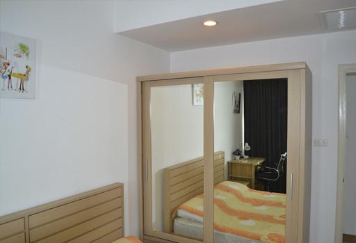 Cozy bedroom with large mirror wardrobe doors and modern lighting