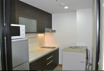 Compact kitchen with modern appliances and white cabinetry