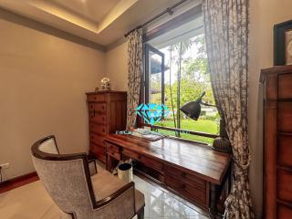 Elegant home office with a classic wooden desk, chair, and large window