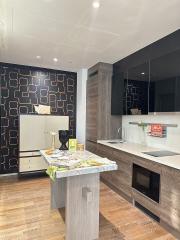 Modern kitchen with wooden floors and geometric wallpaper