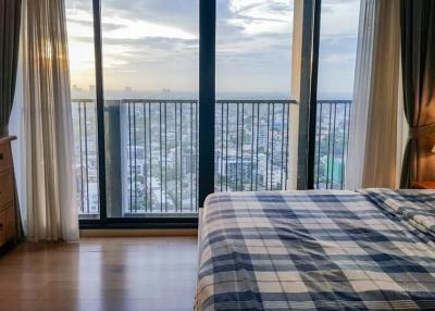 Cozy bedroom with a large window overlooking the city skyline