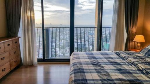 Cozy bedroom with a large window overlooking the city skyline