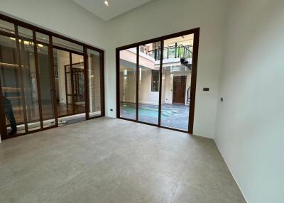 Spacious empty room with large glass doors and tiled flooring