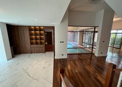 Spacious and modern living room with marble flooring and hardwood floors leading to an outdoor area
