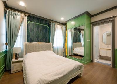Elegant Bedroom Interior with Green Accents and Ensuite Bathroom