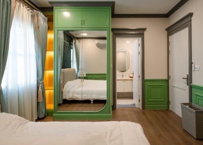 Elegant bedroom with green cupboard and en-suite bathroom