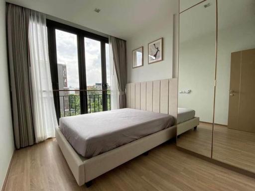 Cozy bedroom with wooden flooring and city view