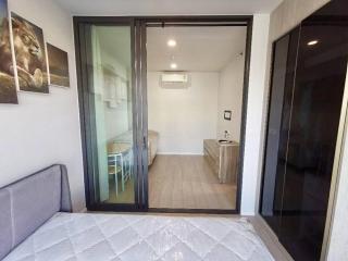 Cozy modern bedroom with sliding glass door leading to a small balcony