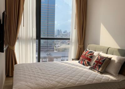 Modern bedroom with a large window overlooking the city