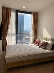 Modern bedroom with a large window overlooking the city